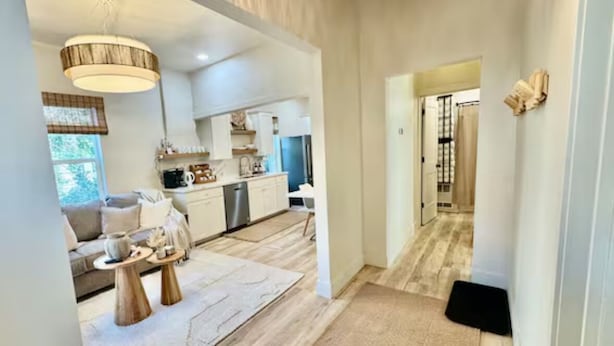 A modern interior with a living area, kitchen, and hallway.