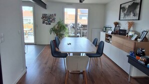 Una cocina moderna con un amplio comedor, sillas azules y vistas al exterior.