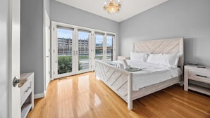 Une chambre à coucher avec un grand lit, une table de chevet, une commode et un lustre.