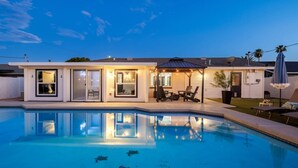 A modern house with a swimming pool, a covered patio, and a well-lit exterior. - Ultimate Scottsdale Getaway | Heated Pool & Fire Pit | Game Room (Scottsdale)
