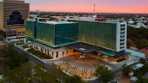 A modern hotel with a glass facade and a rooftop terrace. - Spacious Retreat Perfect for Travelers Seeking Convenience - 2 Units (Mérida)