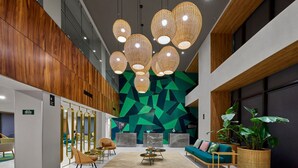 A modern lobby with a geometric wall design, a central seating area with a sofa and chairs, and a coffee table. - Walk to Everything from Your Mérida Rooms - 4 Units (Mérida)