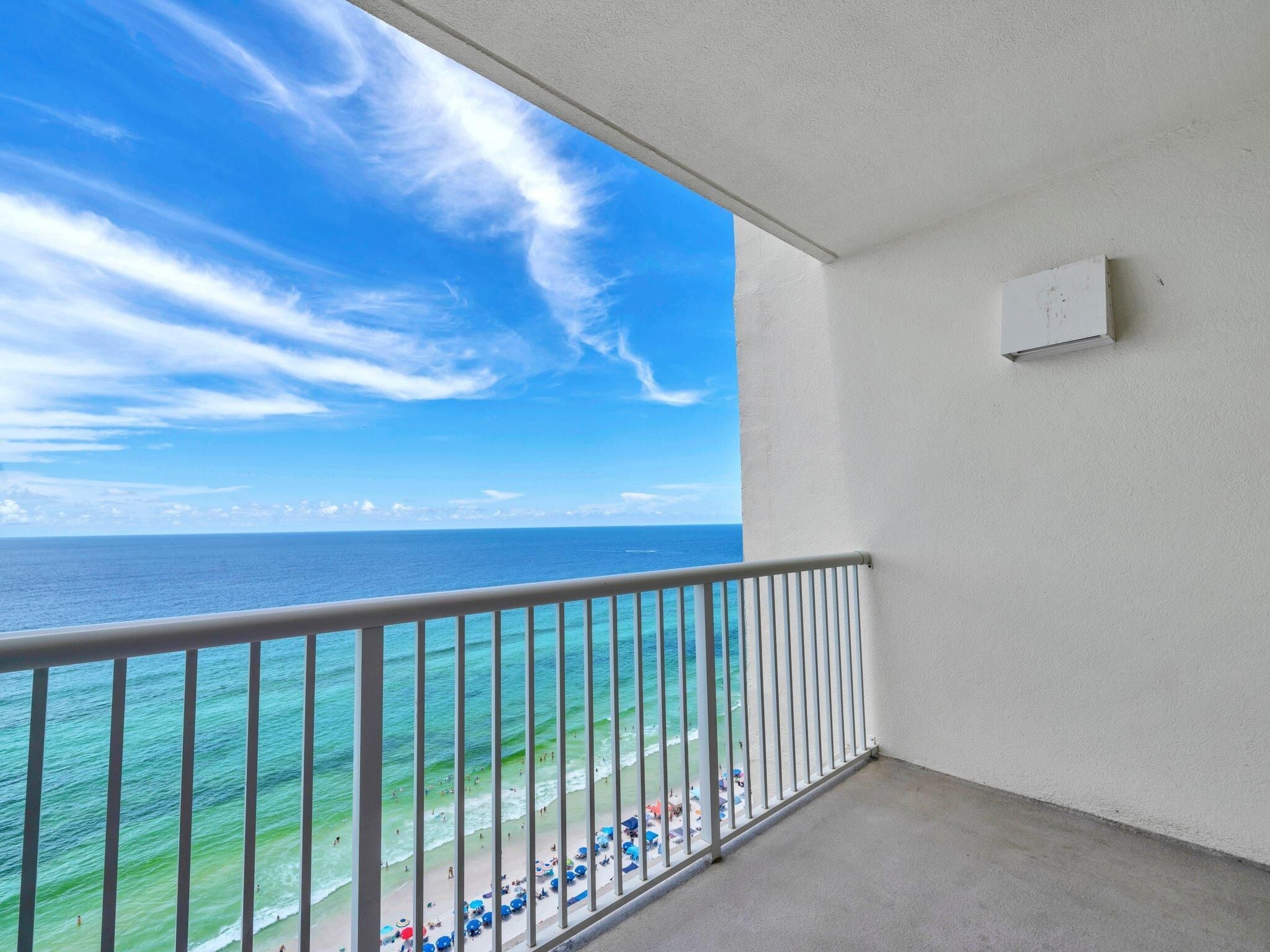 A balcony with a view of the ocean and beach.