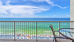 Ein Balkon mit Blick auf Strand und Meer.