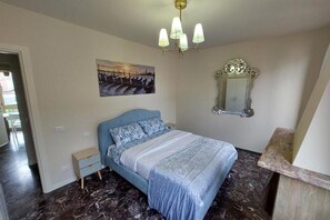 A bedroom with a bed, a nightstand, a mirror, and a painting on the wall. - Donini Residence in Venice, Suite 1 (venezia)