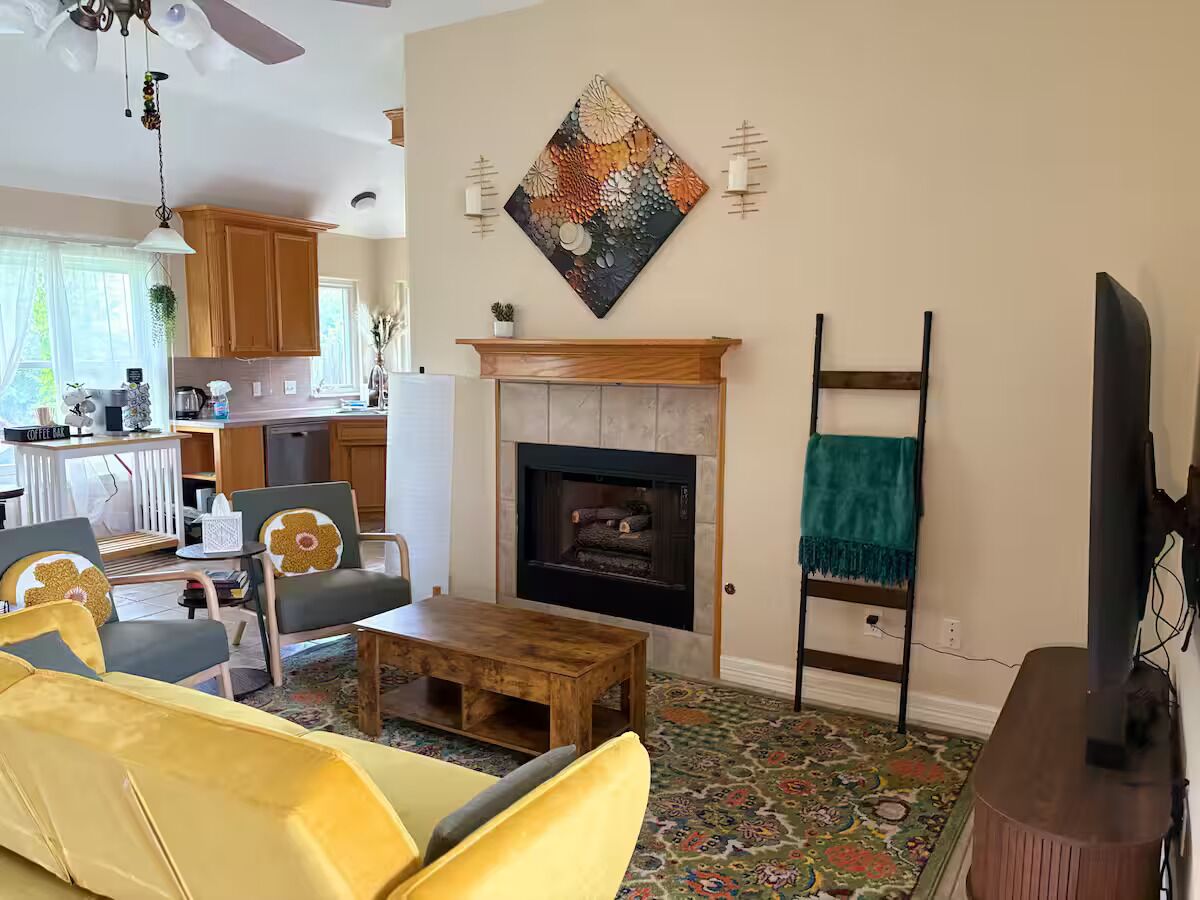 Una sala de estar con chimenea, una mesa de centro y un televisor.