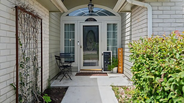 A house with a white exterior, a black welcome sign, and a number 1125 on the door. - Rest In Peace on Perkins (San Marcos)
