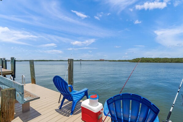 A wooden dock with blue chairs and a cooler, overlooking calm water. - Coastal Breeze Siesta - Turtle (Siesta Key)