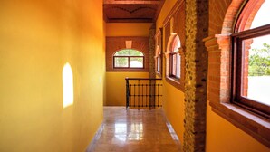 A hallway with yellow walls, a tiled floor, and a brick column. - Ideal fifth for rest! Swimming pool, foosball, barbecue and much more. (San Gabriel las Palmas)