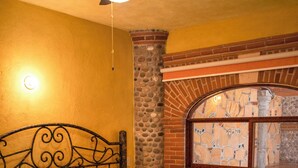 A bed with a headboard, a window with a view, and a ceiling fan. - Ideal fifth for rest! Swimming pool, foosball, barbecue and much more. (San Gabriel las Palmas)