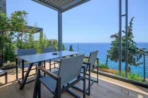 A modern outdoor dining area with a view of the sea. - ELIA Deluxe Studio Suite, Mani Suites (Agios Dimitrios)