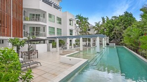 Un hôtel moderne doté d’une piscine, d’un espace extérieur aménagé et d’une végétation luxuriante.