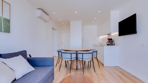 Una sala moderna con un sofá, una mesa de centro y un comedor con sillas.