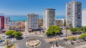 Un hotel moderno con varios pisos, una rotonda central y vista al mar.