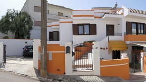 Un edificio residencial con entrada porticada, un balcón y una escalera que conduce a la entrada.