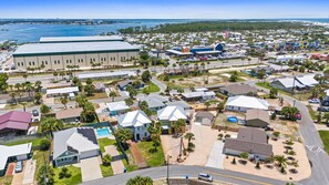 Un quartier résidentiel avec des maisons, un grand immeuble commercial et une plage en arrière-plan.