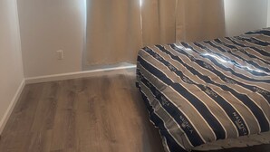 A bedroom with a bed, a ceiling fan, and a window with curtains. - Kalihi Stream, Coffee Bar, Ro Water, Split Ac, WIFI, Black Out Curtain, 4Parking (Honolulu)