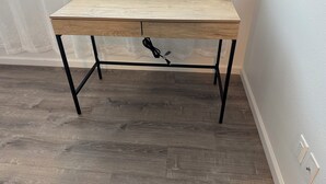 A wooden desk with a drawer, black metal legs, and a cable coiled underneath. - Kalihi Stream, Coffee Bar, Ro Water, Split Ac, WIFI, Black Out Curtain, 4Parking (Honolulu)
