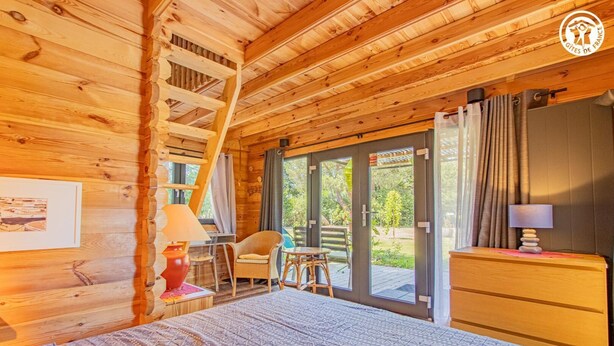 A wooden cabin room with a bed, a desk, a chair, and a dresser. - Gîte des Châtelaines - ANZY LE DUC (ANZY LE DUC)