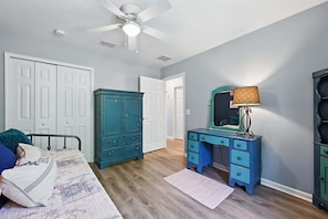 A bedroom with a bed, a dresser, a desk, and a ceiling fan. - Ocean Blue Haven - Family Stay, Historic Downtown (St. Augustine)