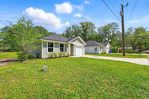 A two-story house with a front yard, a garage, and a utility pole. - Ocean Blue Haven - Family Stay, Historic Downtown (St. Augustine)