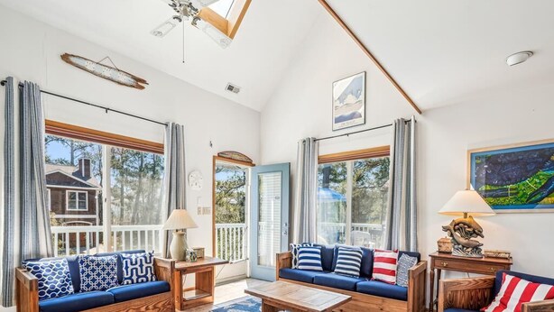 A spacious living area with a wooden sofa set, a coffee table, and a patterned rug. - Spacious 5-Bedroom Home Near Beach (Bethany Beach)