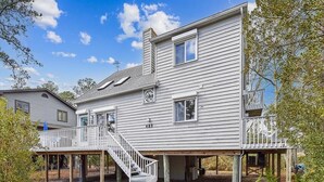 A two-story house with a wooden deck and a staircase leading to a balcony. - Spacious 5-Bedroom Home Near Beach (Bethany Beach)