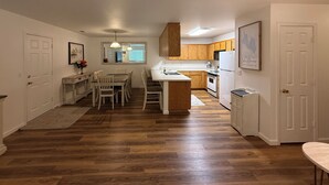 A modern kitchen with wooden cabinets, a central island, and a dining area with chairs. - Charming 3-bedroom house with AC, WiFi in fantastic Susanville (Susanville)
