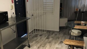 A modern kitchen with a microwave, a sink, and a window with blinds.