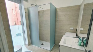 A modern bathroom with a shower, toilet, and sink.