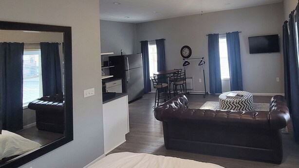 A compact living space with a sofa, a dining table with chairs, a small kitchenette, and a television. - Remodeled downtown studio with remarkable views! (Luverne)