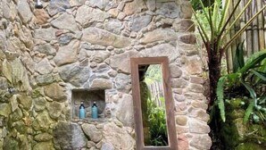 Une pièce aux murs de pierre, dotée d’un plafond en bois, d’une petite fenêtre et d’une porte en bois.