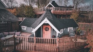 A cabin with a wooden deck and a fenced balcony. - Stunning Tiny House w/ Outdoor Tub & Views (Pontsticill)