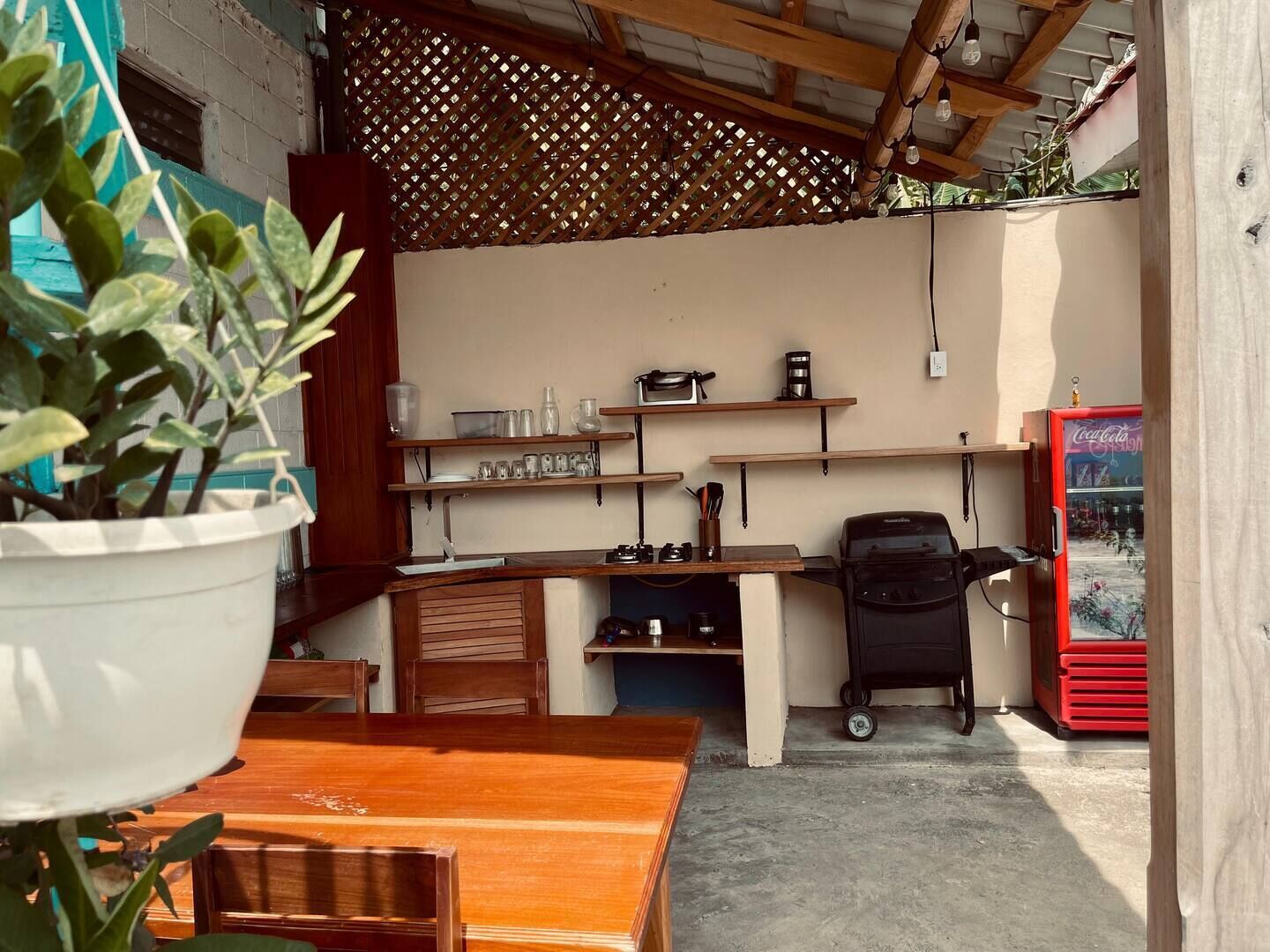A compact kitchen with wooden countertops, a coffee machine, and a refrigerator.