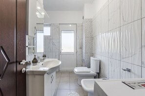 Une salle de bain moderne avec un double lavabo, des toilettes et un espace douche.