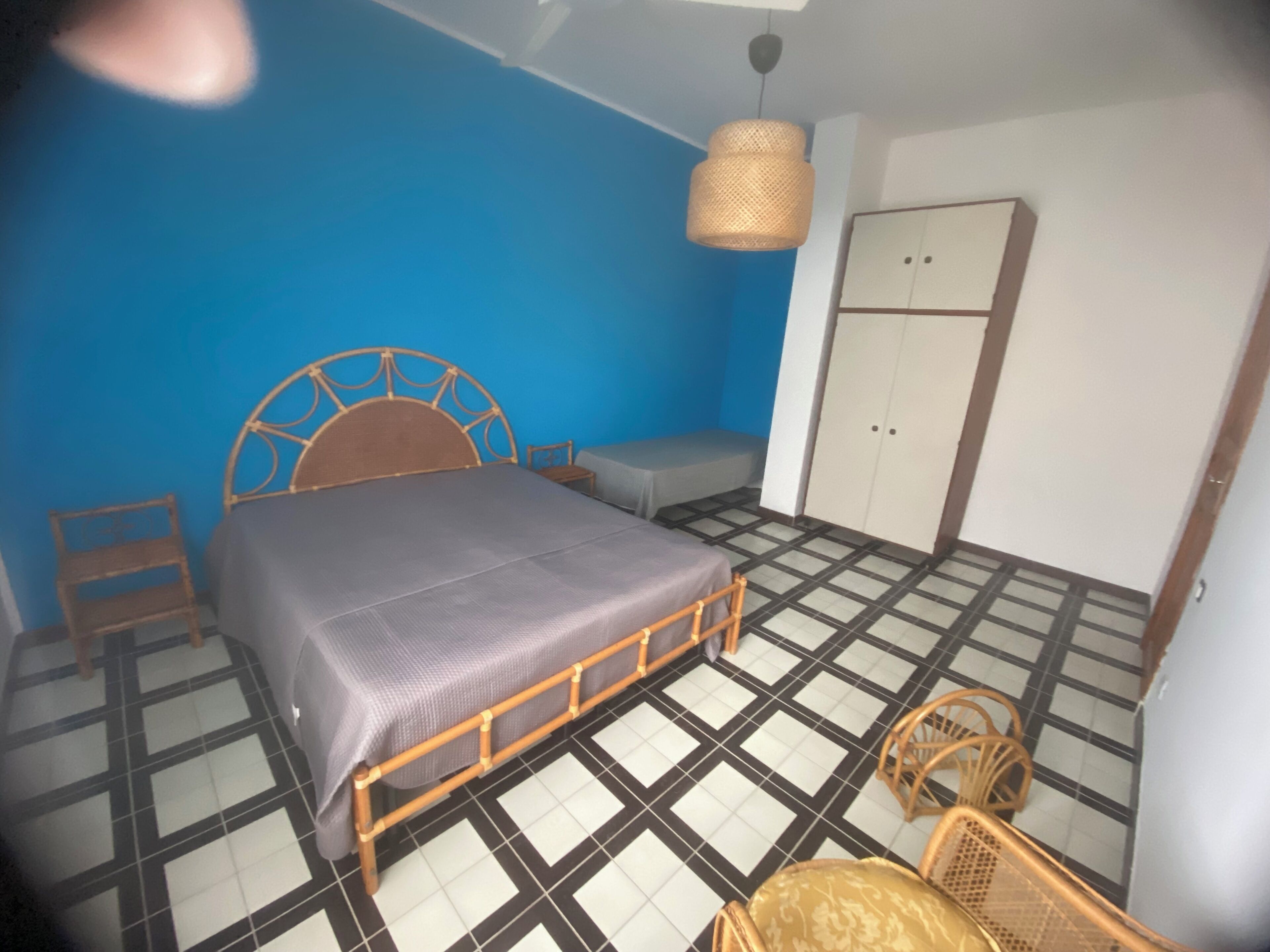 Une chambre à coucher avec un lit, une armoire, un banc et une chaise.