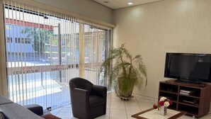 A modern living room with a sofa, armchair, and TV stand.