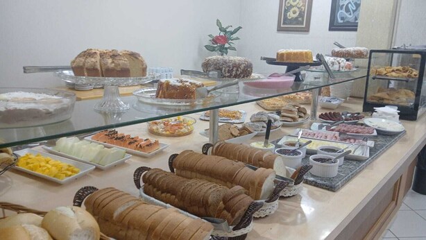 A buffet with various food items including bread, pastries, and fruits.