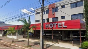 A hotel with a red facade and multiple windows.