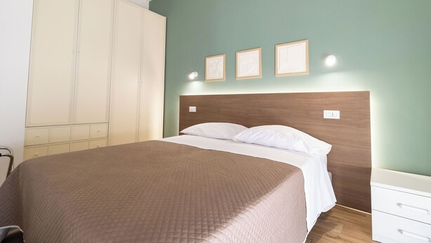Une chambre à coucher avec un lit, une armoire et une table de chevet.