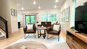 A modern living room with a sofa set, a coffee table, and a TV. - Brand New Lux Mountain Trails Retreat+ 3BR 3BA Sleeps 6
NEW HOT TUB!! (Bella Vista)