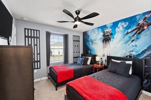 A hotel room with two beds, a ceiling fan, a large window, and a space-themed mural on the wall.