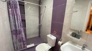 Ein Badezimmer mit Dusche, Toilette und Waschbecken.