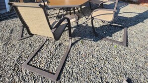 An outdoor patio with a table and four chairs, a large umbrella, and a gravel ground. - Easy access to I-5, Hwy 99. 1 bus stop from Aurora Transit Center. (Edmonds)