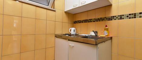 Cocina compacta con horno integrado, hervidor y pileta.
