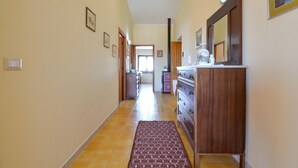 A hallway with a wooden dresser, a rug, and framed pictures on the walls. - Amazing apartment in Suni with WiFi (Suni)