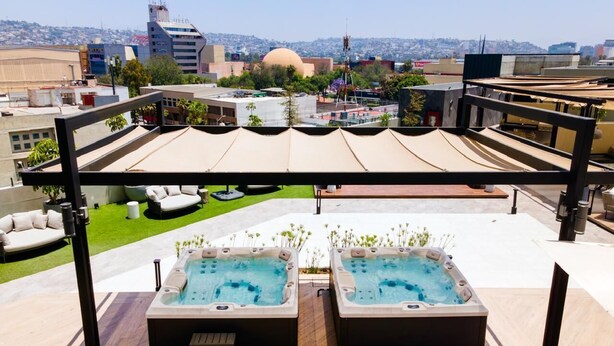 A rooftop terrace with two hot tubs, a covered seating area, and a view of the cityscape. - Modern Studio in Zona Rio with Panoramic View / Eazy stay / Tijuana (tijana)