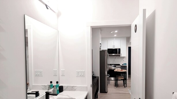 A modern kitchen with white cabinets, a black refrigerator, and a microwave. - Luxury Guest Suite in Calgary perfect for a visit to the Canadian Rockies. (Calgary)