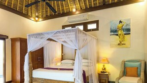 Un dormitorio con cama con dosel, un armario de madera, una silla de mimbre y un cuadro en la pared.