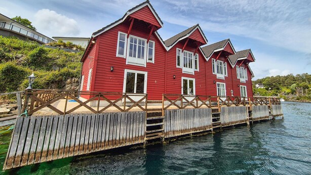 A red wooden house with a dock extending into a body of water. - 2 bedroom stunning home in Lepsøy (Lepsøy)